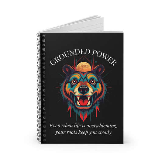 Notebook with a colorful abstract bear head portrait, intense expression, flowing mane, geometric accents, and paint splatters on a black background, featuring the words "GROUNDED POWER" and quote "Even when life is overwhelming, your roots keep you steady".