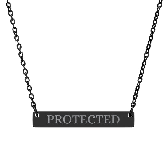 Black bar necklace with engraved uppercase text "PROTECTED" on a matte black pendant, suspended on a delicate black chain. Minimalist motivational affirmation jewelry for protection and empowerment.
