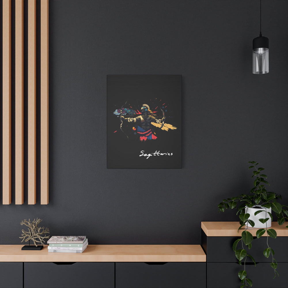 Black canvas wall art print of abstract Sagittarius archer with bow, dynamic pose, flowing cape, and colorful splatters on dark background, featuring "Sagittarius" in elegant white cursive hung on a dark grey wall above a wooden shelf with potted plants.