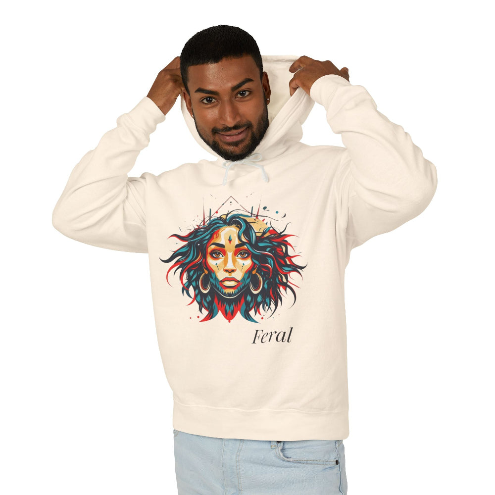 Young man with short hair pulling up the hood of a cream hoodie featuring vibrant artistic portrait of a fierce woman with curly multicolored flowing hair, teal red blue face accents, large hoop earrings, third-eye symbol, "Feral" text below