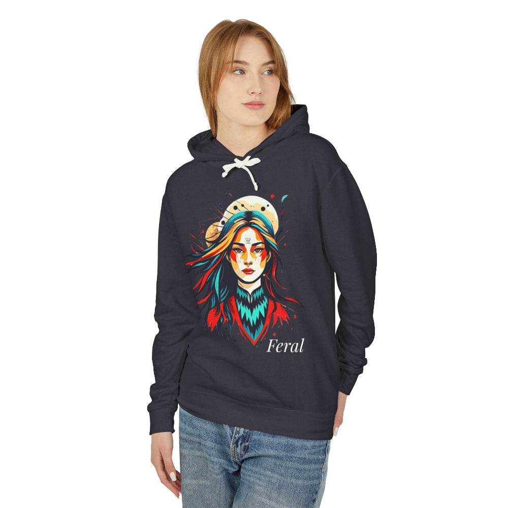 Young woman modeling black hoodie with vibrant artistic portrait of a fierce woman with long multicolored flowing hair, teal and red face paint, colorful splash design, third-eye motif, "Feral" text below