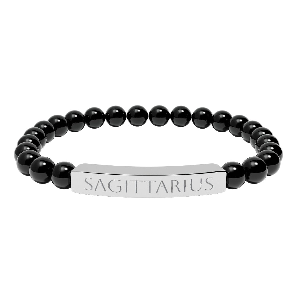 Bracelet with polished black onyx beads and silver curved bar engraved "SAGITTARIUS" in uppercase letters. Stretch-fit zodiac-inspired crystal jewelry.