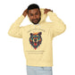 Young man with short hair pulling up the hood of a pale yellow hoodie featuring vibrant multicolored bear head graphic, roaring expression, fur in blue orange teal splashes, orange moon above, "GROUNDED POWER" arched text, motivational quote about roots and steadiness below
