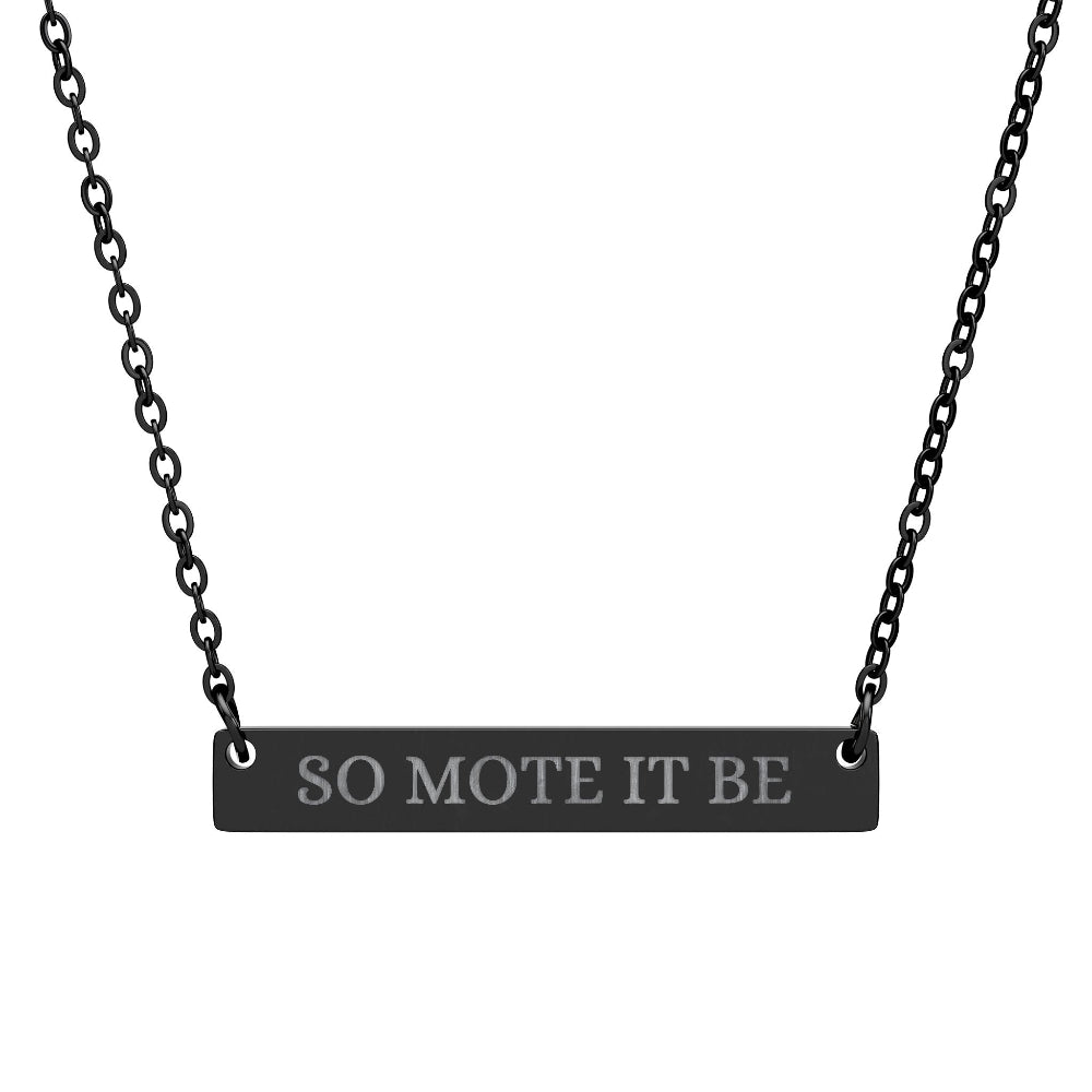 Black bar necklace featuring engraved silver text "SO MOTE IT BE" on a matte black pendant, suspended on a delicate black chain. Minimalist occult-inspired jewelry with Wiccan/Pagan affirmation for manifestation and intention setting.