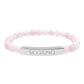 Bracelet with polished rose quartz beads in soft pink tones, natural veining and translucent glow, featuring a silver curved bar engraved "SCORPIO" in uppercase letters. Stretch-fit zodiac-inspired crystal jewelry for intensity, transformation, and emotional depth.