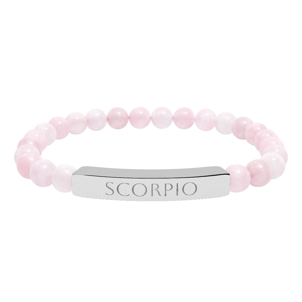 Bracelet with polished rose quartz beads in soft pink tones, natural veining and translucent glow, featuring a silver curved bar engraved "SCORPIO" in uppercase letters. Stretch-fit zodiac-inspired crystal jewelry for intensity, transformation, and emotional depth.