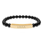 Bracelet with polished black onyx beads and gold-plated curved bar engraved "LIBRA" in uppercase letters. Stretch-fit zodiac-inspired crystal jewelry.