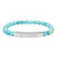 Bracelet with polished turquoise beads in soft aqua-blue tones with natural veining and speckles, featuring a silver curved bar engraved "SCORPIO" in uppercase letters. Stretch-fit zodiac-inspired crystal jewelry for intensity, transformation, and emotional depth.