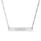 Silver bar necklace with engraved uppercase text "LOVED" on a sleek matte silver pendant, suspended on a delicate matching silver chain. Minimalist motivational affirmation jewelry for self-love, worthiness, and emotional healing.