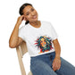 White unisex cotton t-shirt modeled by smiling woman with braided hair, hand on cheek, featuring bold "Feral" graphic on chest: vibrant abstract portrait of a fierce woman with wild flowing multicolored hair, intense expression, tribal markings, colorful geometric accents, and dynamic paint splatters in red, orange, teal, blue, and gold tones bursting outward. White elegant cursive "Feral" text below. Wild feminine energy motivational crewneck tee.