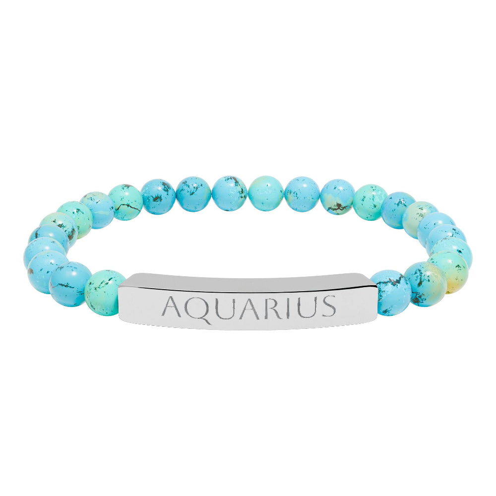 Bracelet with polished turquoise beads in soft aqua-blue tones with natural veining and speckles, featuring a silver curved bar engraved "AQUARIUS" in uppercase letters. Stretch-fit zodiac-inspired crystal jewelry.
