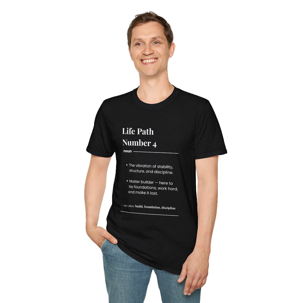 Black unisex cotton t-shirt modeled by smiling man with short brown hair, featuring bold Life Path Number 4 numerology print in dictionary style: "Life Path Number 4 noun · The vibration of stability, structure, and discipline. · Master builder — here to lay foundations, work hard, and make it last. – see also: build, foundation, discipline". Motivational spiritual numerology crewneck tee.