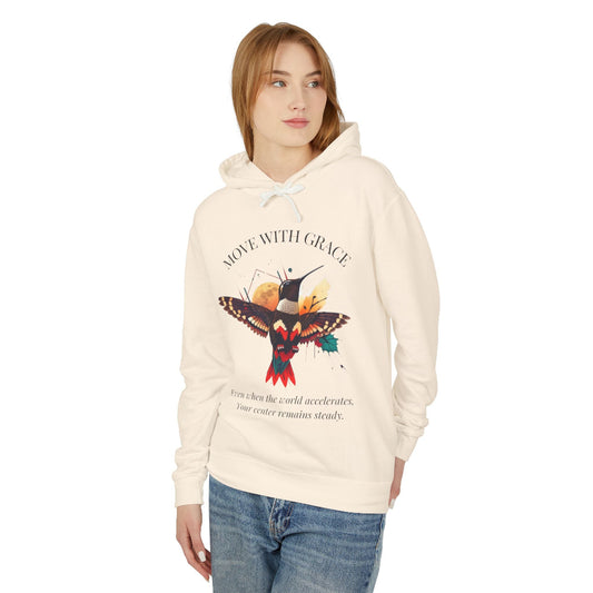 Women's cream-colored "Move With Grace" hummingbird graphic hoodie. Features a vibrant nature-inspired illustration and inspirational quote in black text.