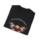 Black folded unisex cotton t-shirt featuring bold "Transformation" graphic print: vibrant abstract butterfly with detailed wings, intense expression, colorful geometric accents, and dynamic paint splatters in red, orange, teal, blue, and gold tones bursting outward around an orange moon background. Arched white text "TRANSFORMATION" above. Motivational spiritual empowerment crewneck tee flat lay.
