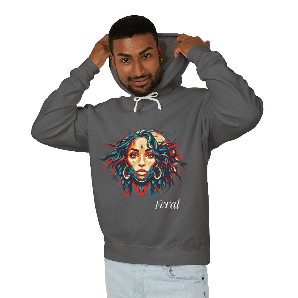 Young man with short hair pulling up the hood of a dark gray hoodie featuring vibrant artistic portrait of a fierce woman with curly multicolored flowing hair, teal red blue orange face accents, large hoop earrings, third-eye symbol, "Feral" text below