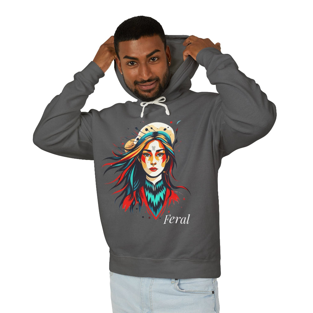 Young man with short hair pulling up the hood of a gray hoodie featuring vibrant artistic print of a fierce woman with long flowing hair, red-orange armored top, colorful paint splash design, "Feral" text below