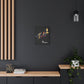 Black canvas wall art print of colorful abstract mirrored fish with flowing fins and cosmic splatters on dark background, featuring "Pisces" in elegant white cursive hung on a dark grey wall above a wooden shelf with potted plants.