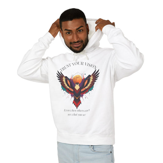 Young man modeling white hoodie with colorful abstract eagle/phoenix graphic, "TRUST YOUR VISION" arched above, and inspirational quote "Even when others can't see what you see" below, pulling up hood