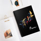 Notebook with a colorful abstract pair of mirrored fish swimming, detailed scales, flowing fins, and paint splatters on a black background, featuring the word "Pisces" in elegant white cursive, placed on a minimal white desk with sunglasses and stationery items.