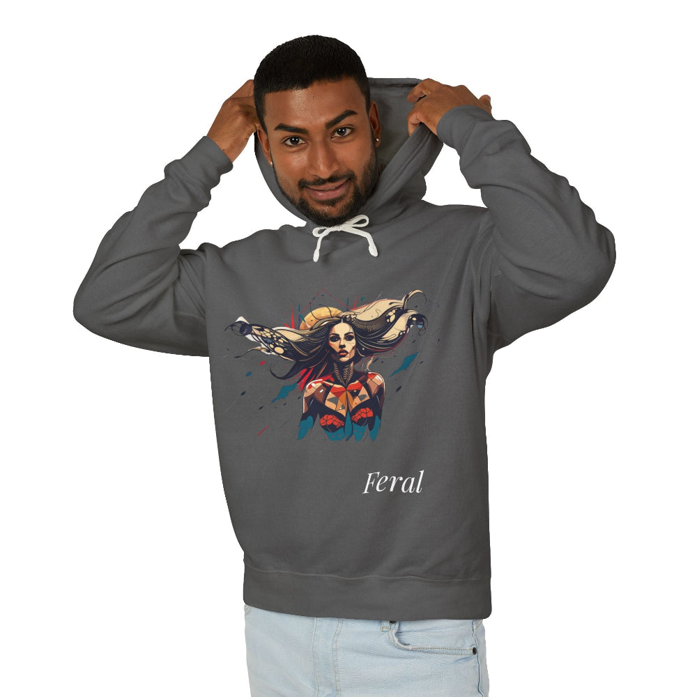 Young man with short hair pulling up the hood of a grey hoodie featuring vibrant artistic print of a fierce woman with long flowing hair, red-orange armored top, colorful paint splash design, "Feral" text below