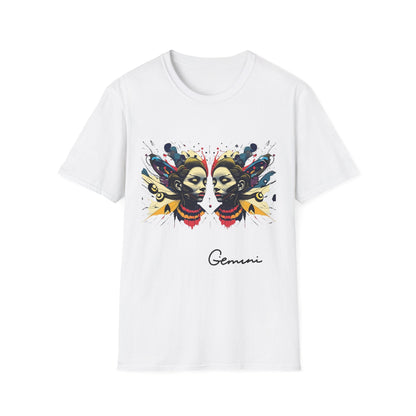 White unisex cotton t-shirt featuring bold Gemini zodiac graphic: vibrant abstract twin female faces with flowing hair, intense expressions, geometric patterns, and dynamic multicolored paint splatters in gold, red, navy, teal, and black tones exploding outward to form butterfly wings. Elegant black cursive "Gemini" text below. Astrology zodiac motivational crewneck tee.