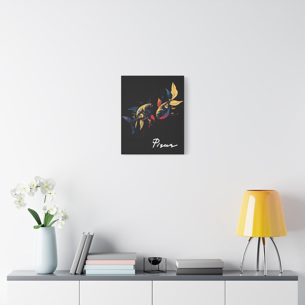 Black canvas wall art print of colorful abstract mirrored fish with flowing fins and cosmic splatters on dark background, featuring "Pisces" in elegant white cursive displayed in a modern home décor setting above a console table with books and yellow lamp.
