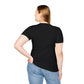 Black unisex cotton t-shirt back view on plus-size female model with long brown hair, hands on hips: plain blank black with no print, short sleeves, fitted style, curved hem, and natural drape. Soft comfortable premium basic black t-shirt rear view for women.