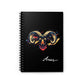 Notebook with a colorful abstract Aries ram head portrait, large curved horns, intense expression, and paint splatters on a black background, featuring the word "Aries".