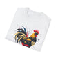 White folded unisex cotton t-shirt featuring bold Year of the Rooster zodiac graphic print: vibrant abstract rooster portrait with detailed feathers, proud stance, intense eyes, red comb and wattles, geometric accents, and dynamic multicolored paint splatters in gold, red, black, blue, teal, and orange tones exploding outward. Chinese text "鸡年" (Year of the Rooster) printed below in black. Chinese New Year zodiac motivational crewneck tee.