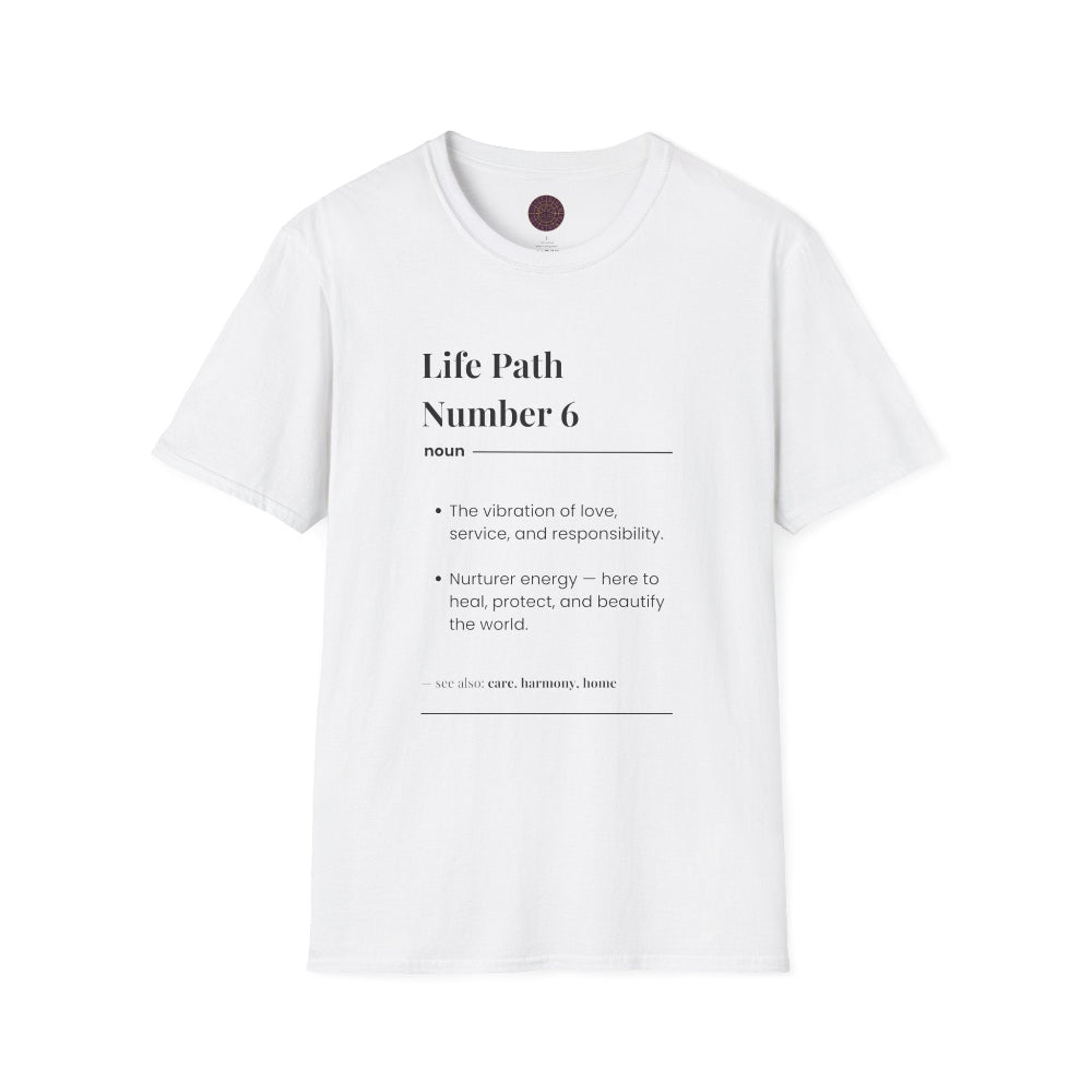 White unisex cotton t-shirt flat lay featuring bold Life Path Number 6 numerology print: dictionary-style definition text reading "Life Path Number 6 noun · The vibration of love, service, and responsibility. · Nurturer energy — here to heal, protect, and beautify the world. – see also: care, harmony, home". Motivational spiritual numerology crewneck tee with visible purple/gold zodiac wheel inner tag.
