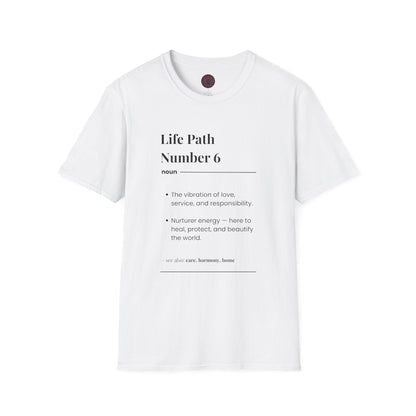 White unisex cotton t-shirt flat lay featuring bold Life Path Number 6 numerology print: dictionary-style definition text reading "Life Path Number 6 noun · The vibration of love, service, and responsibility. · Nurturer energy — here to heal, protect, and beautify the world. – see also: care, harmony, home". Motivational spiritual numerology crewneck tee with visible purple/gold zodiac wheel inner tag.
