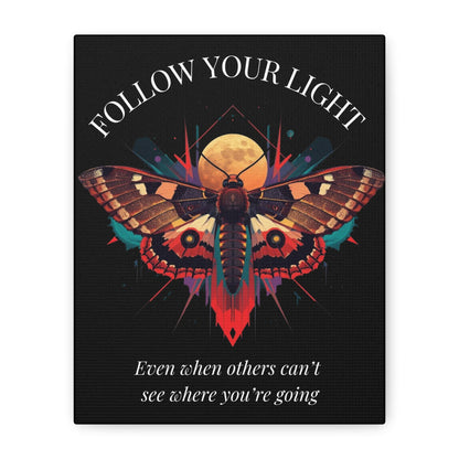 Close up of black canvas wall art print featuring colorful abstract moth with detailed wings, intense expression, geometric accents, and cosmic splatters on dark background. Arched white text "FOLLOW YOUR LIGHT" above and quote "Even when others can't see where you're going, see with your own eyes" below. 