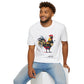 White unisex cotton t-shirt modeled by smiling man with curly hair and beard, featuring bold Year of the Rooster zodiac graphic: vibrant abstract rooster portrait with detailed feathers, intense eyes, proud stance, geometric accents, and dynamic multicolored paint splatters in gold, red, black, blue, teal, and orange tones exploding outward. Chinese text "鸡年" (Year of the Rooster) printed below in black. Zodiac Chinese New Year motivational crewneck tee.