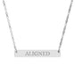 Silver bar necklace with engraved uppercase text "ALIGNED" on a sleek matte silver pendant, suspended on a delicate matching silver chain. Minimalist motivational affirmation jewelry for alignment, balance, and spiritual harmony.