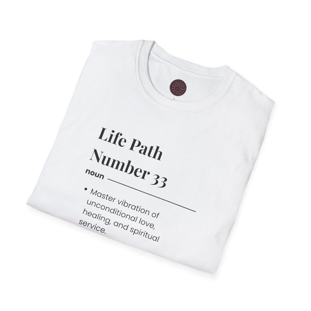 White folded unisex cotton t-shirt featuring bold Life Path Number 33 numerology print in dictionary style: exact text reading "Life Path Number 33 noun · Master vibration of unconditional love, healing, and spiritual service." Motivational spiritual numerology crewneck tee flat lay with visible purple/gold zodiac wheel inner tag.