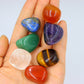 Set of 7 polished tumbled healing crystals on palmof a hand : amethyst, carnelian, tiger's eye, green aventurine, clear quartz, red jasper, lapis lazuli, natural gemstones for chakra balancing and meditation, zen display with white background