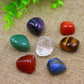 Set of 7 polished tumbled healing crystals on bamboo tray: amethyst, carnelian, tiger's eye, green aventurine, clear quartz, red jasper, lapis lazuli, natural gemstones for chakra balancing and meditation, zen display with green leaves background