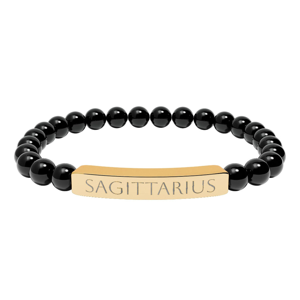 Bracelet with polished black onyx beads and gold-plated curved bar engraved "SAGITTARIUS" in uppercase letters. Stretch-fit zodiac-inspired crystal jewelry for adventure, optimism, and truth-seeking.