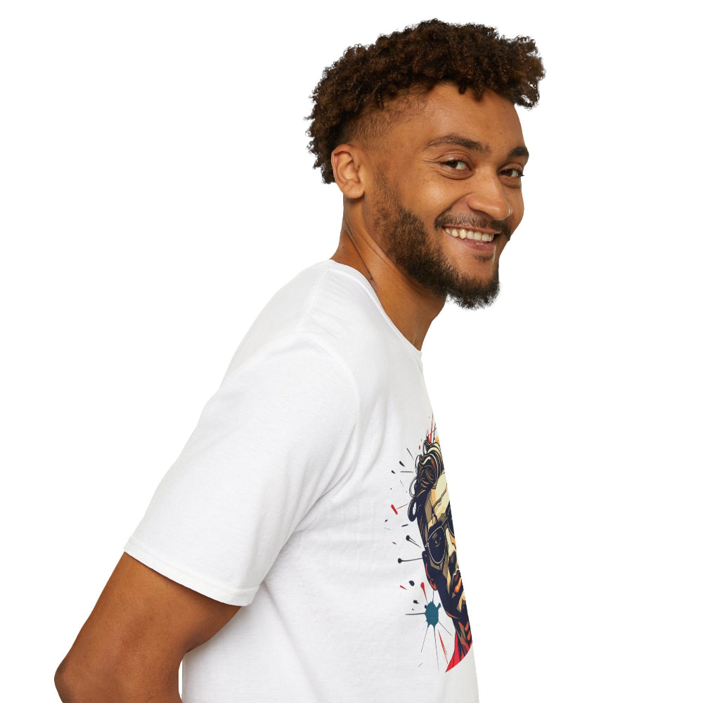 White unisex cotton t-shirt modeled by smiling man with curly hair and beard, featuring bold "Primal" graphic on chest: stylized intense man portrait with short hair, vibrant red, blue, yellow, and black paint splatters bursting outward. Primal masculine energy motivational crewneck tee.