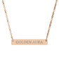 Rose gold bar necklace with engraved uppercase text "GOLDEN AURA" on a sleek matte pendant, suspended on a delicate matching rose gold chain. Minimalist motivational affirmation jewelry for radiance, positivity, and energetic glow.