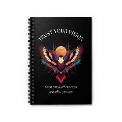 Close up of notebook with a colorful abstract phoenix/eagle with spread wings, intense expression, and paint splatters on a black background, featuring the words "TRUST YOUR VISION" and quote "Even when others can't see what you see".