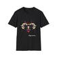Black unisex cotton t-shirt featuring bold Capricorn zodiac graphic: vibrant abstract goat/ram head portrait with large curved horns, intense glowing eyes, geometric diamond accents, flowing beard details, and dynamic multicolored paint splatters in gold, red, navy, teal, and black tones exploding outward. Elegant white cursive "Capricorn" text below. Astrology zodiac motivational crewneck tee.