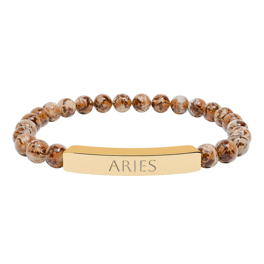 Bracelet with polished leopard jasper beads in earthy brown tones with natural veining, featuring a gold-plated curved bar engraved "ARIES" in uppercase letters. Stretch-fit zodiac-inspired crystal jewelry for passion, courage, and leadership.
