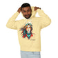 Young man with short hair pulling up the hood of a yellow hoodie featuring vibrant artistic print of a fierce woman with long flowing hair, red-orange armored top, colorful paint splash design, "Feral" text below