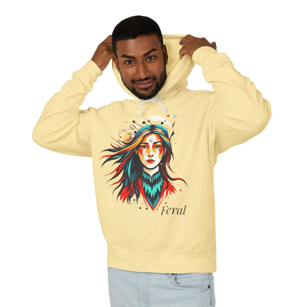 Young man with short hair pulling up the hood of a yellow hoodie featuring vibrant artistic print of a fierce woman with long flowing hair, red-orange armored top, colorful paint splash design, "Feral" text below