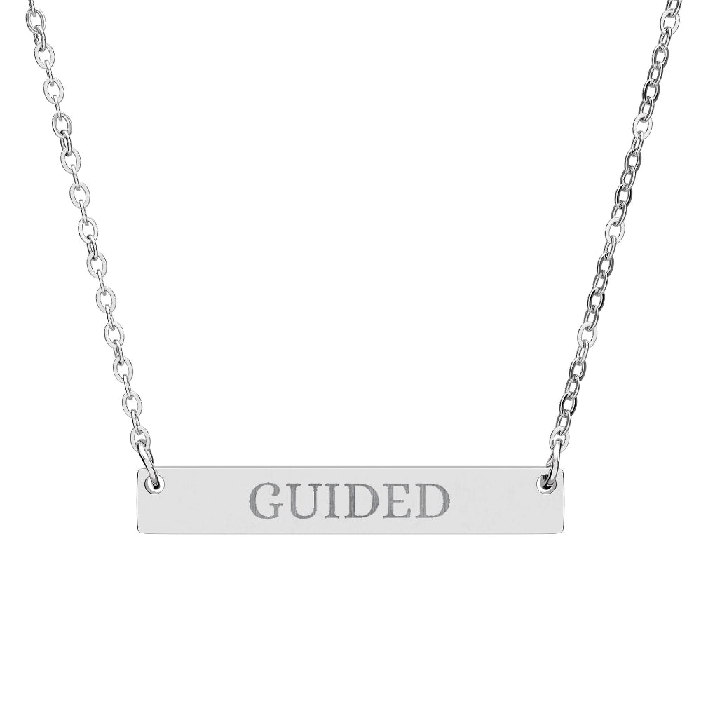 Silver bar necklace with engraved uppercase text "GUIDED" on a sleek matte silver pendant, suspended on a delicate matching silver chain. Minimalist motivational affirmation jewelry for guidance, intuition, and spiritual alignment.
