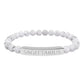 Bracelet with polished white howlite beads featuring natural gray-black veining and marbling, paired with a silver curved bar engraved "SAGITTARIUS" in uppercase letters. Stretch-fit zodiac-inspired crystal jewelry.