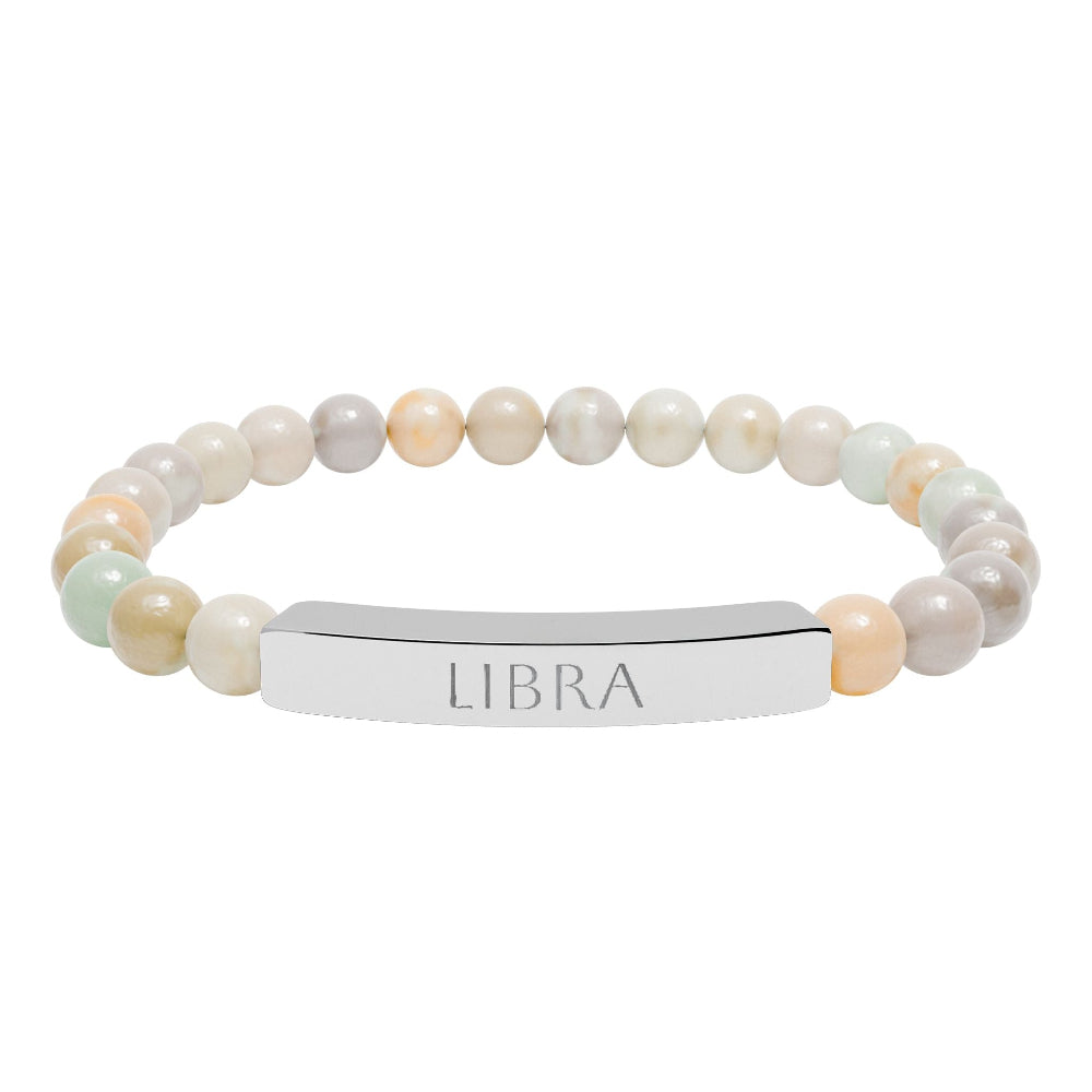 Bracelet with polished pastel beads in soft peach, cream, gray, and light blue tones with natural marbling, featuring a silver curved bar engraved "LIBRA" in uppercase letters. Stretch-fit zodiac-inspired crystal jewelry.