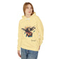 Young woman modeling pale yellow hoodie with vibrant artistic print of a fierce woman with flowing long hair, red-orange armored top, colorful paint splash design, "Feral" text below