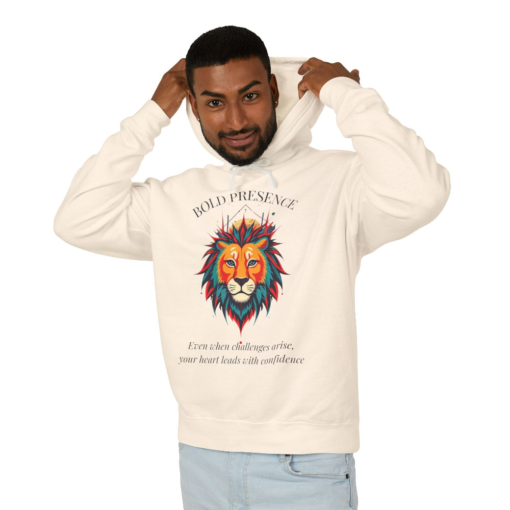 Young man with short hair pulling up the hood of a cream hoodie featuring colorful lion head graphic, mane in orange teal blue splashes, "BOLD PRESENCE" arched text, motivational quote about heart-led confidence below